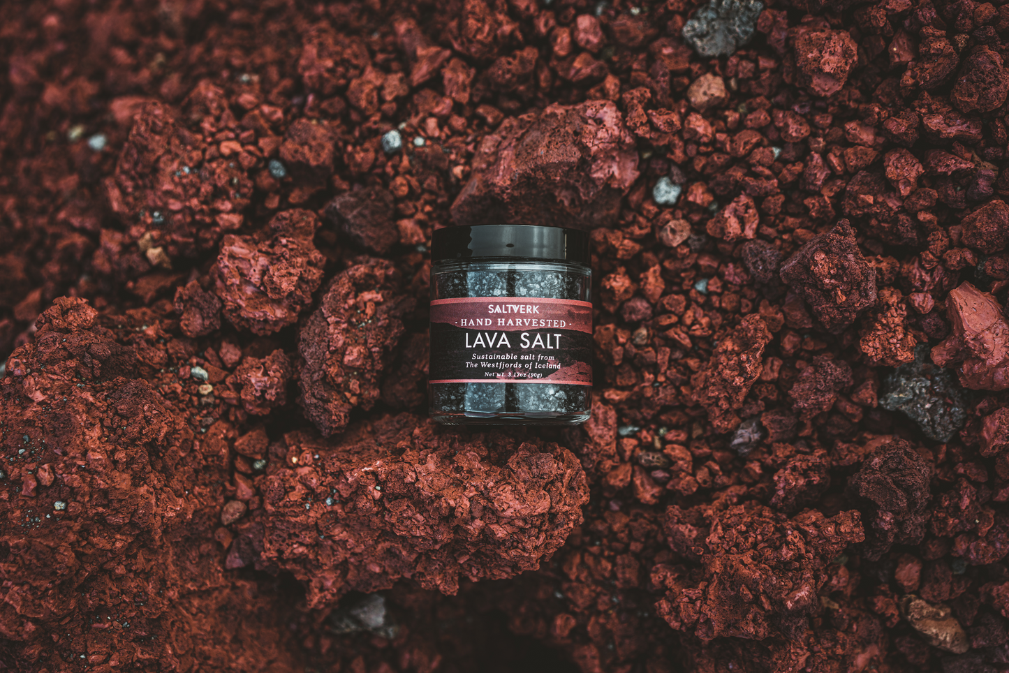 Jar of lava salt on a bed of red volcanic rock