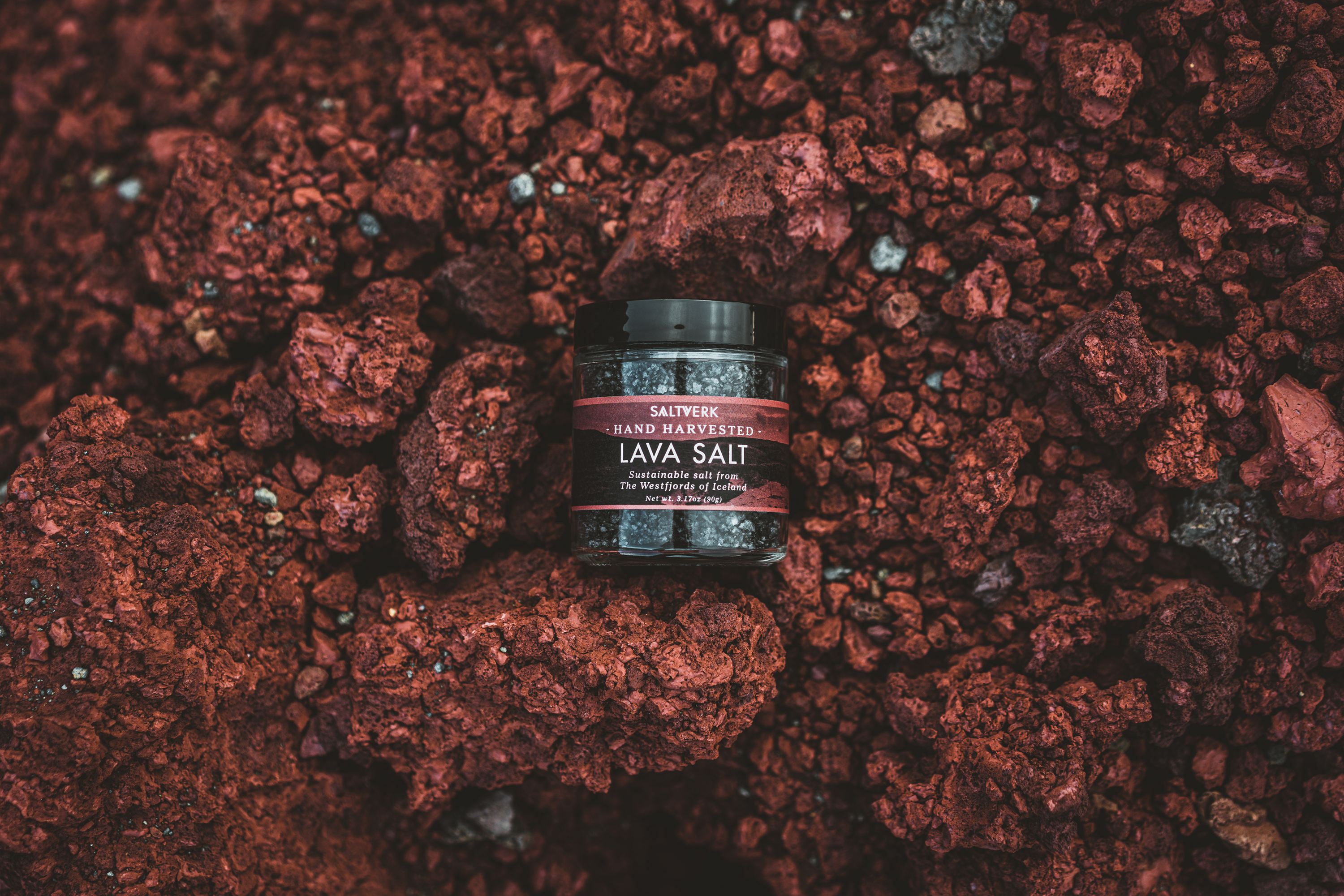 Jar of lava salt on a bed of red volcanic rock